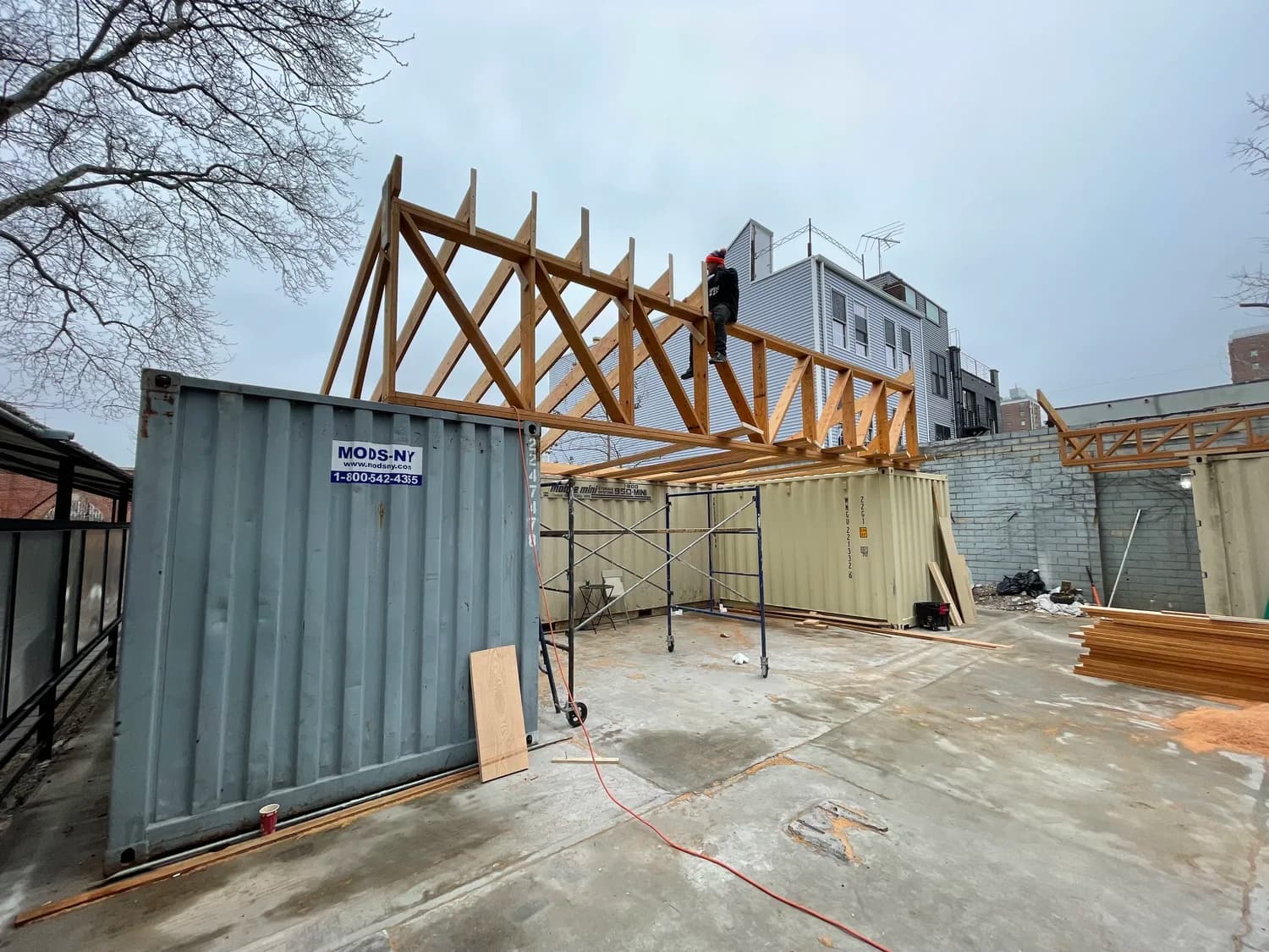 FIG. 02 — The Nursery buildout — timber trusses over containers